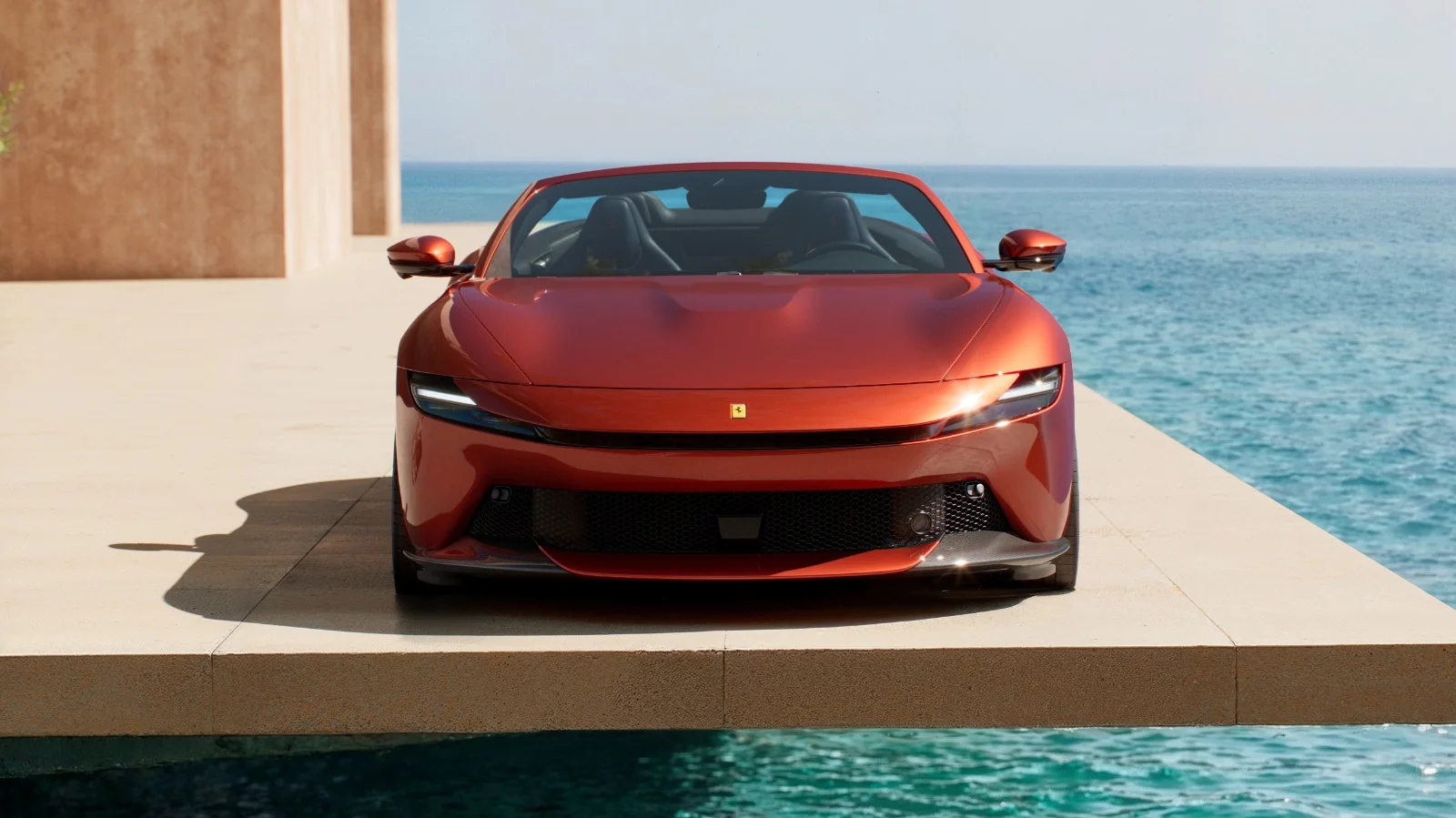 Ferrari Amalfi Spider in Rosso Tramonto driving along a coastal highway at sunset