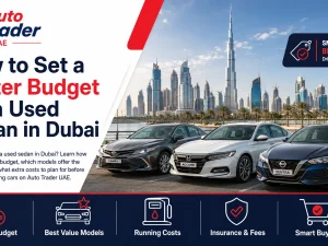 Used sedans parked in Dubai with city skyline in the background